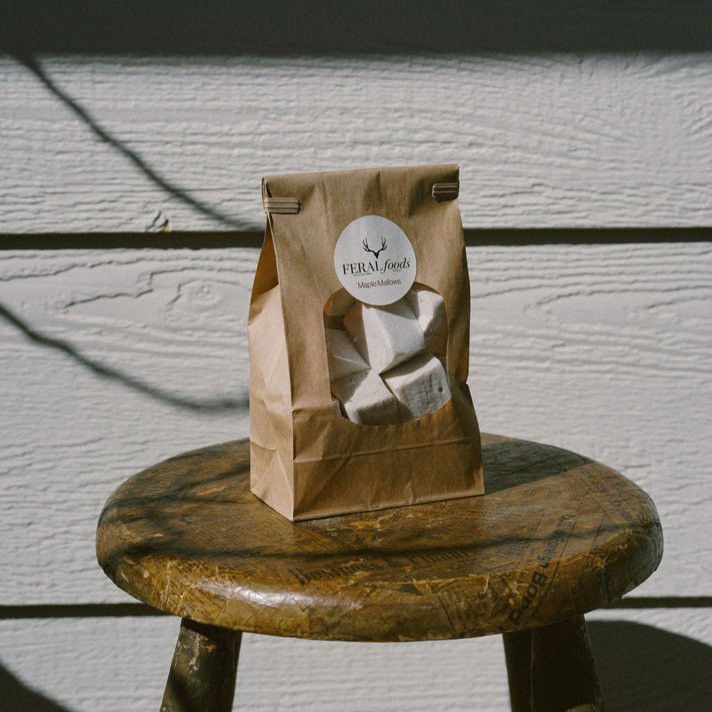 A package of Maple Mallows sitting on a wooden stool outdoors, with a shadow cast across the surface.